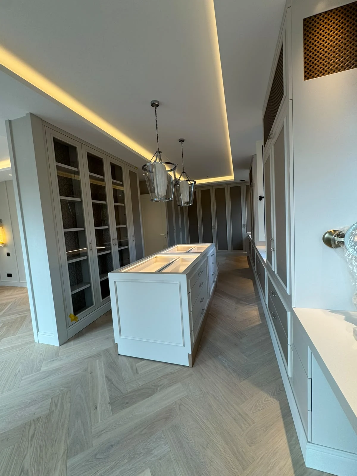 Profilierte Einbauten, abgestimmte Farbtöne und warmes Deckenlicht im räumlichen Zusammenhang.